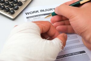 A man with a bandaged hand signing a form.