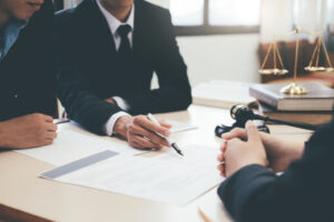 An accident at work solicitor sat at a desk pointing to a document with a pen.