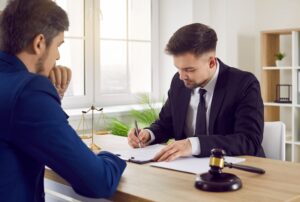 Two work injury solicitors in suits sat at a desk working on a case