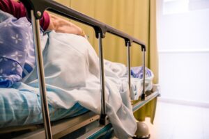 A woman lays in a hospital bed alone