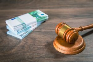 A stack of bank notes on a table next to a gavel representing compensation for facial scarring.