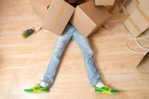 A worker lying on the floor after being hit by heavy boxes at work.