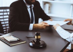 A criminal injury solicitor hands a form to a client