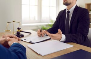 A solicitor explaining the data breach claims process to his client at a desk