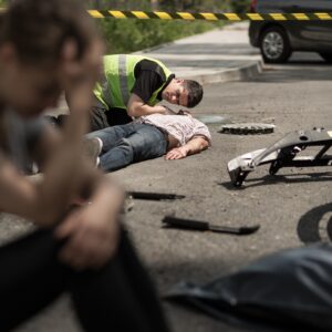 A man being tended to by a paramedic having sustained crush injuries during a car accident