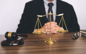 A breach of data protection solicitor sitting behind a desk with gold scales in front of him