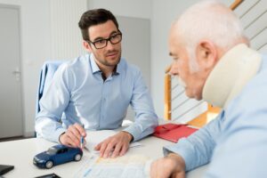 CLOSE UP OF A PERSON COMPLETING AN ACCIDENT AT WORK PERSONAL INJURY CLAIM REPORT 