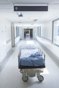 A hospital bed in an empty corridor.