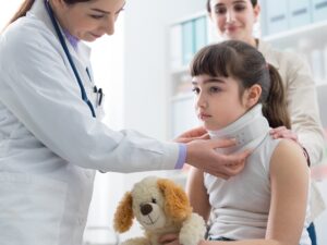 A child with a neck injury is seen by a doctor.