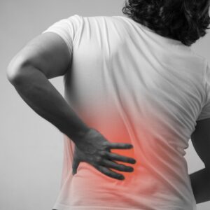 A person from behind with their back pain illustrated in red. 