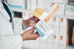 A pharmacist holding various medication boxes