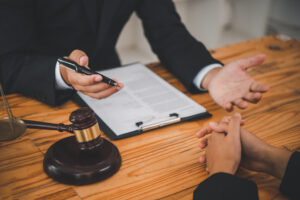 A solicitor takes notes while giving advice and sitting at his desk.