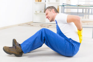 A man holds his back after being injured at work.