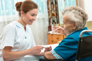 A carer helping a resident take their daily medication in a home